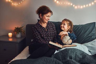 Happy friends sitting on sofa