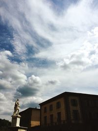 Low angle view of building against cloudy sky