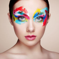 Close-up of woman with face paint against white background