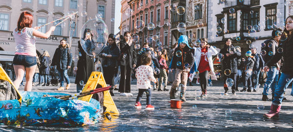 People on street amidst buildings in city