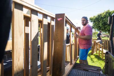 Men lift wood furniture into back of truck on moving day.