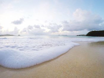 View of beach against cloudy sky