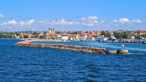 Scenic view of sea by buildings against sky