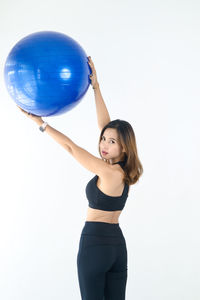 Young woman with balloons against white background