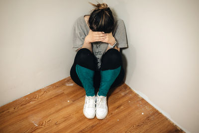 Low section of woman standing on hardwood floor at home