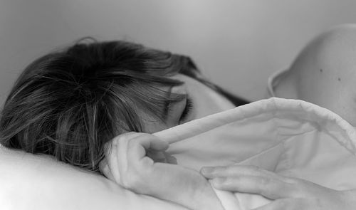 Close-up of woman relaxing on bed at home