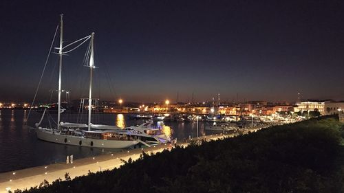 Boats moored in harbor at night