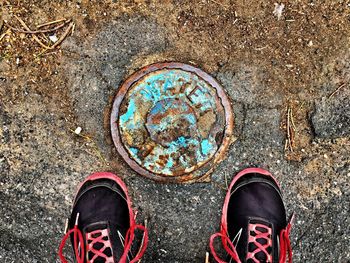 Low section of man standing by multi colored shoes