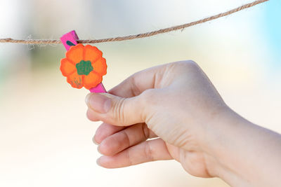 Close-up of man holding hand against sky