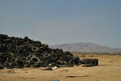 Stack of stones on field against sky