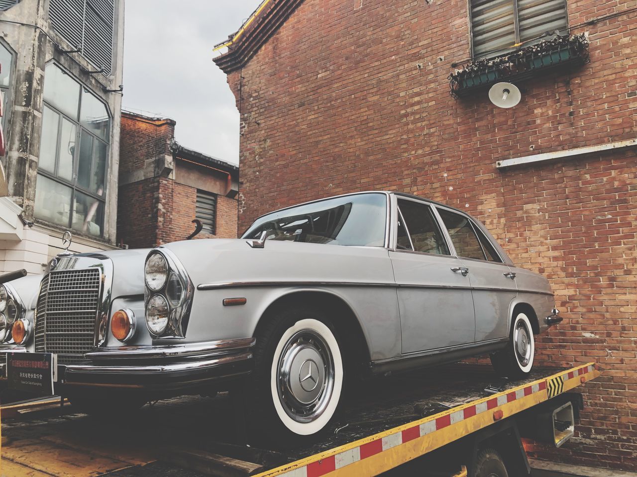 mode of transportation, building exterior, architecture, motor vehicle, built structure, car, transportation, land vehicle, city, retro styled, building, day, vintage car, street, no people, stationary, old, brick, brick wall