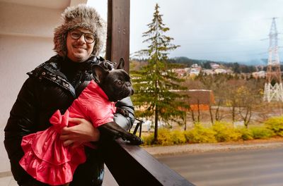 Man with dog in balcony at mountain during winter