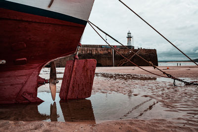 Sailboat moored on beach against sky