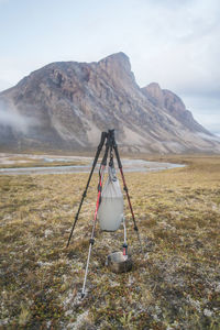 Gravity fed water filter held by tripod made with trekking poles.