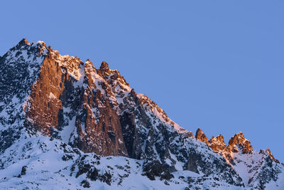 Low angle view of snowcapped mountain against sky