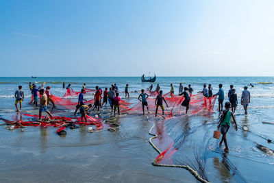 People in sea against clear sky