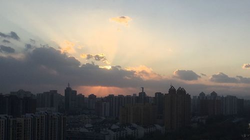 View of cityscape against cloudy sky during sunset