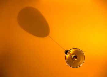 Low angle view of light bulb against orange sky