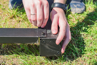 Worker with a hand tool assembling metal construction outdoors