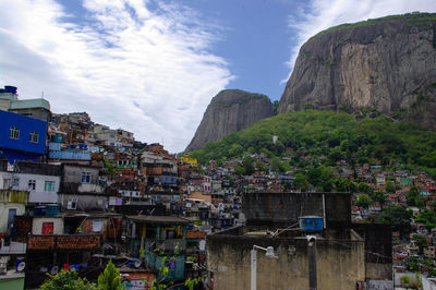 Houses by mountain against sky