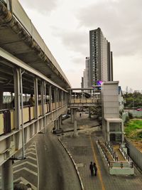 Road by buildings in city against sky