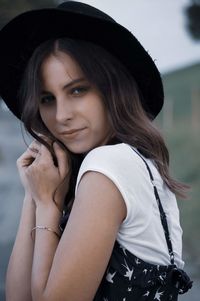 Portrait of young woman wearing hat outdoors