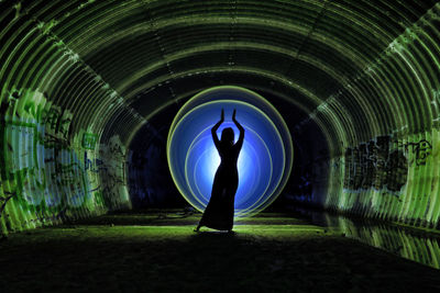 Rear view of silhouette man standing in tunnel