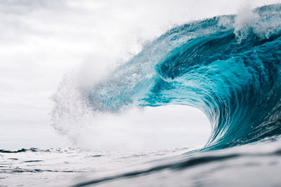 Water splashing in sea against sky