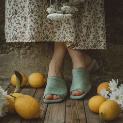 Low section of woman standing on wooden floor