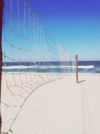 Net on beach against sky