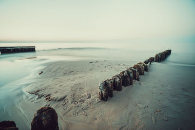 Scenic view of beach against clear sky during sunset