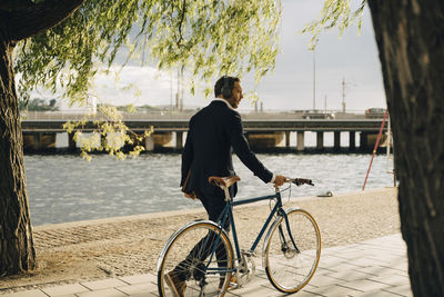 Side view of man riding bicycle in city