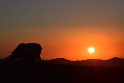 Silhouette landscape against sky during sunset