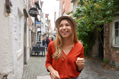 Smiling tourist woman strolling in schnoor neighborhood, bremen, germany