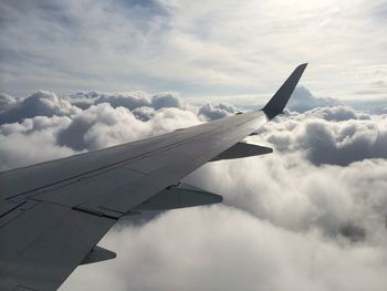 Cropped image of airplane against cloudy sky