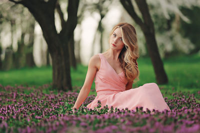 Portrait of woman sitting on flowering plants