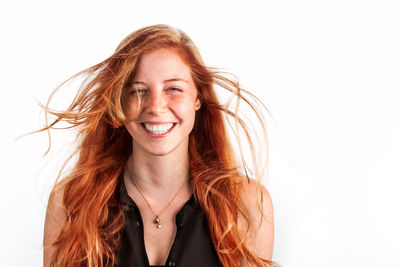 Portrait of a smiling young woman against white background