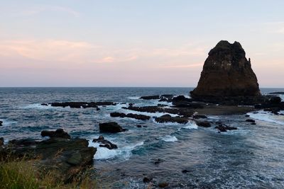 Scenic view of rock formation in sea against sky