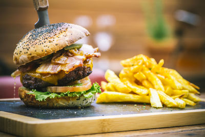 Close-up of french fries and burger served on table