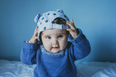 Cute girl with cap sitting on bed