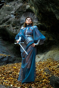 Portrait of woman standing against rock