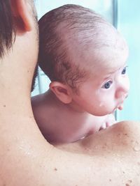 Shirtless father carrying baby girl