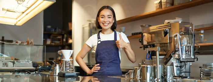 Portrait of young woman standing in cafe