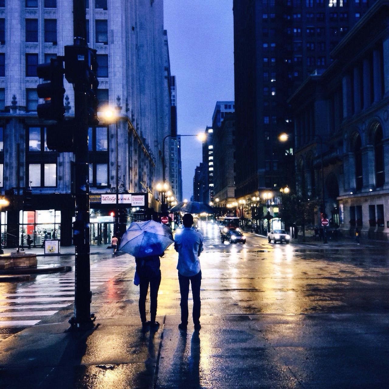 building exterior, architecture, built structure, city, street, walking, city life, illuminated, lifestyles, men, city street, person, large group of people, night, street light, building, full length, wet, leisure activity