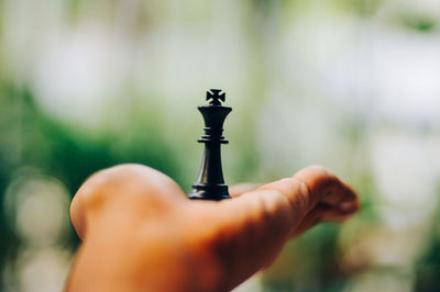 Close-up of person hand holding camera against blurred background