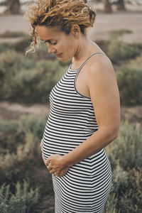 Pregnant woman standing on grassy field