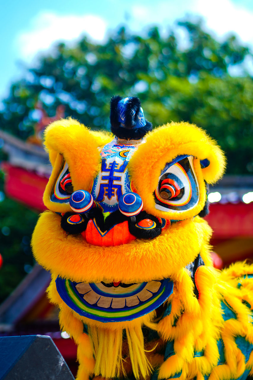 yellow, chinese new year, celebration, tradition, festival, event, animal representation, holiday, representation, dragon, focus on foreground, outdoors, dancing, multi colored, chinese dragon, nature, arts culture and entertainment, craft, day, animal, flower, decoration, sky, carnival, plant