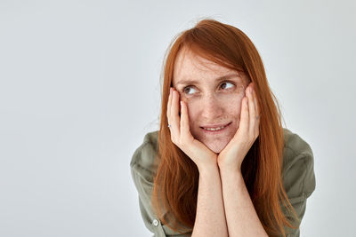 Portrait of smiling young woman over white background