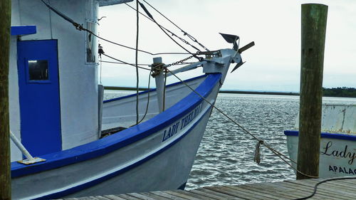 Ship moored on sea against blue sky