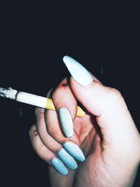 Close-up of hand holding cigarette